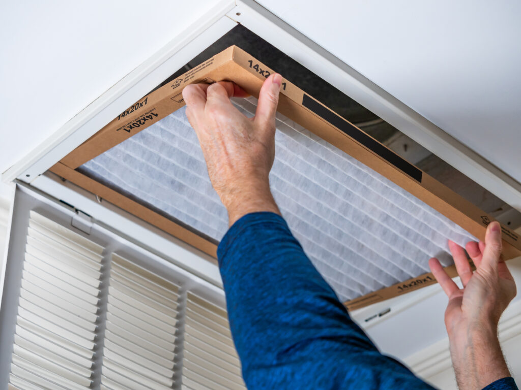 HVAC technician replacing a home air filter in Burlingame