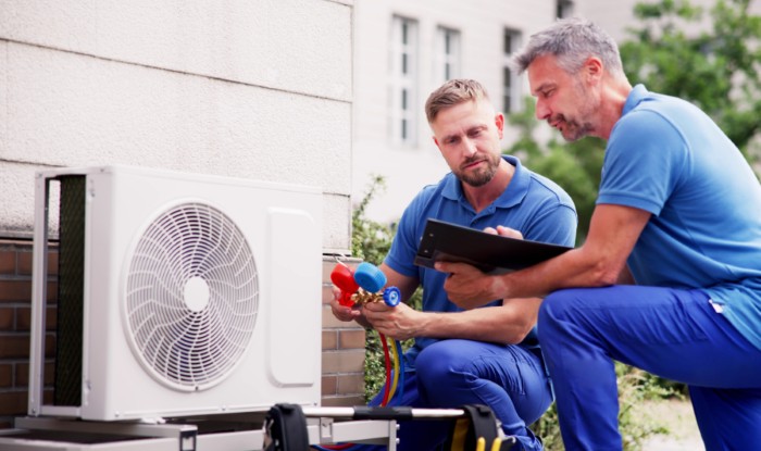 HVAC technicians installing an outdoor air conditioning unit in Burlingame