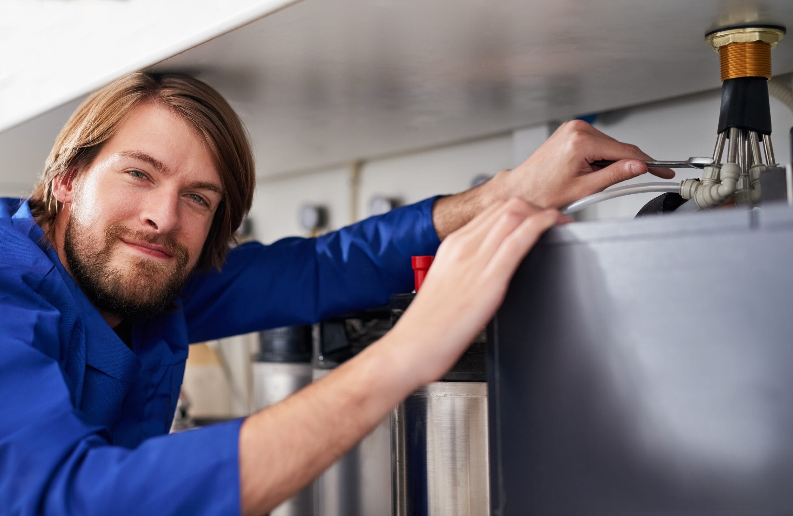 Technician servicing a residential water heater tank in Burlingame
